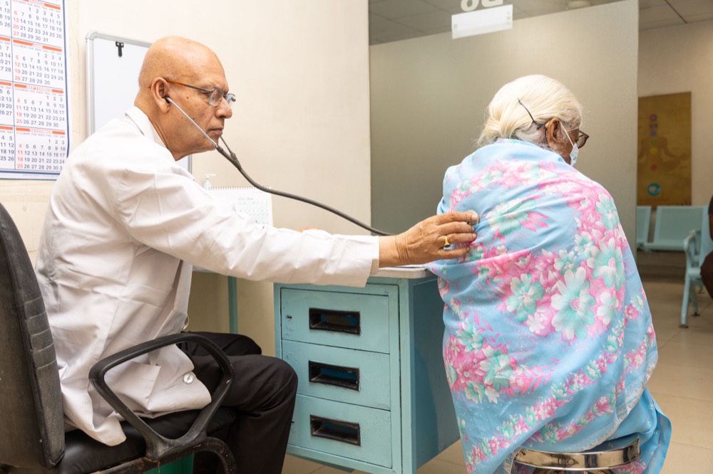 A senior Nanda Medical Center physician examining a long-standing patient